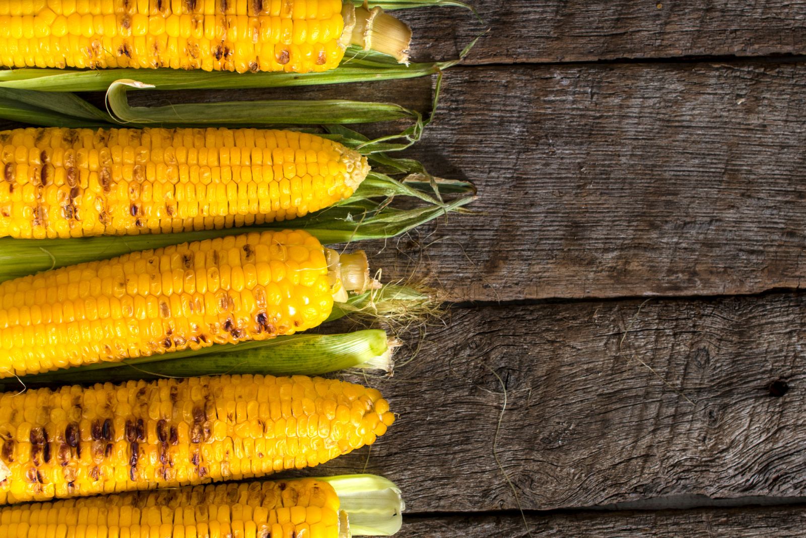 Grilled corn on wood table by badmanproduction via iStock